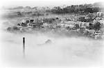 England, Halifax.  An overhead view of a mill chimney and houses on a foggy morning.