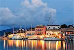 Greece, Kefalonia, Fiskardo. Reflections of harbour lights at dusk.