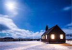 Budir, Snaefellsness peninsula, Western Iceland, Europe. Black church of Budir at night with full moon.