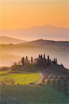 Valdorcia, Siena, Tuscany, Italy. Tuscan farm on top of a hill at sunrise.