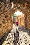 Vigoleno, Piacenza, Emiglia-Romagna, Italy. Woman walking inside the castle walls.