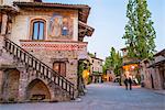 Grazzano Visconti, Vigolzone, Piacenza district, Emilia Romagna, Italy. A couple walking among the typical old houses of the village at dusk.