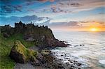 United Kingdom, Northern Ireland, County Antrim, Bushmills. The ruins of the 13th century Dunluce Castle.