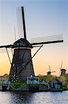 Netherlands, South Holland, Kinderdijk, UNESCO World Heritage Site. Historic Dutch windmills on the polders at sunset.