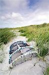 Scotland, Argyll and Bute, Isle of Tiree. Old lobster pot buried in sand dunes.