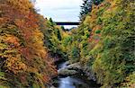 Scotland, Pitlochry. People on the bridge over the River Garry in autumn, near the Pass of Killiecrankie.