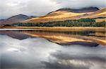 Scotland, Argyll and Bute, Bridge of Orchy. Reflections of mountains and trees at Loch Tulla in the autumn.