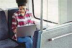 Woman with laptop while sitting in train