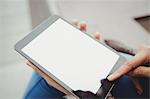 Cropped image of woman using tablet computer while sitting outdoors