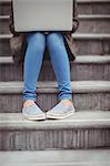 Low angle view of woman using laptop while sitting on steps