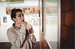 Young woman looking towards board at railroad station