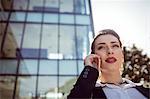 Businesswoman talking on phone outside office building