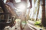 Low section of mountain biker riding in forest