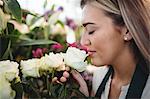 Close-up of female florist smelling flower at her flower shop