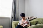 Mother feeding her baby in living room at home