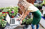 Female florist using laptop in garden centre