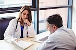 Female doctor at her desk talking to patient in the hospital