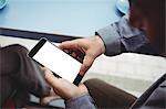 Close-up of man text messaging on mobile phone in cafeteria