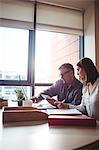 Man discussing with colleague over laptop in the office