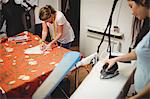 Two female fashion designers working in the studio