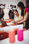 Female fashion designer working on tablet in the studio