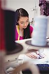 Female dressmaker sewing on the sewing machine in the studio