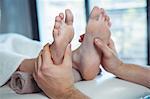 Male physiotherapist giving foot massage to female patient in clinic