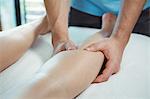 Close-up of physiotherapist giving physical therapy to the leg of a female patient in the clinic