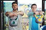 Man and woman exercising with kettlebell in the clinic