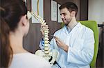 Physiotherapist explaining the spine to female patient in the clinic