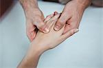 Close-up of physiotherapist massaging hand of a female patient in the clinic