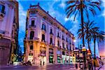 Ornate architecture along Via Roma in the shopping district at dusk, in the historic city of Palermo in Sicily, Italy