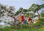 Small group of young friends playing outdoors, watching bubbles in air