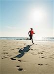 Mature woman running on a beach at sunset