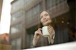 Businesswoman gazing through cafe window, Freiburg, Germany