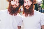 Portrait of young male hipster twins with red beards wearing white tshirts