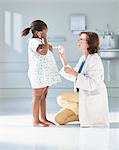 Girl listening to doctors stethoscope in hospital children's ward