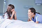 Girl patient talking to female nurse in hospital children's ward