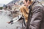 Happy young couple pointing at lake, Lake Como, Italy