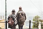 Rear view of young couple looking out at misty Lake Como, Italy