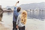 Young couple taking smartphone selfie on lakeside, Lake Como, Italy