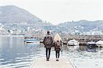 Rear view of young couple on pier looking out at Lake Como, Italy