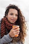 Young woman holding cup of coffee on cold day