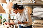 Mature female customer reading lamp price tag in gift shop