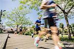 Blurred motion of runners running on park boardwalk