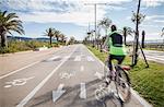 Rear view of cyclist wear high vis jacket  cycling in cycle lane