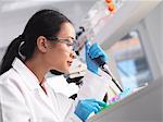 Scientist pipetting a sample into a phial during an experiment in a laboratory