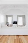 White living room with vaulted wood beam ceiling in home showcase interior