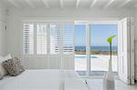 White bedroom home showcase open to swimming pool and ocean view