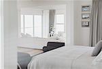 White bedroom open to living room in home showcase